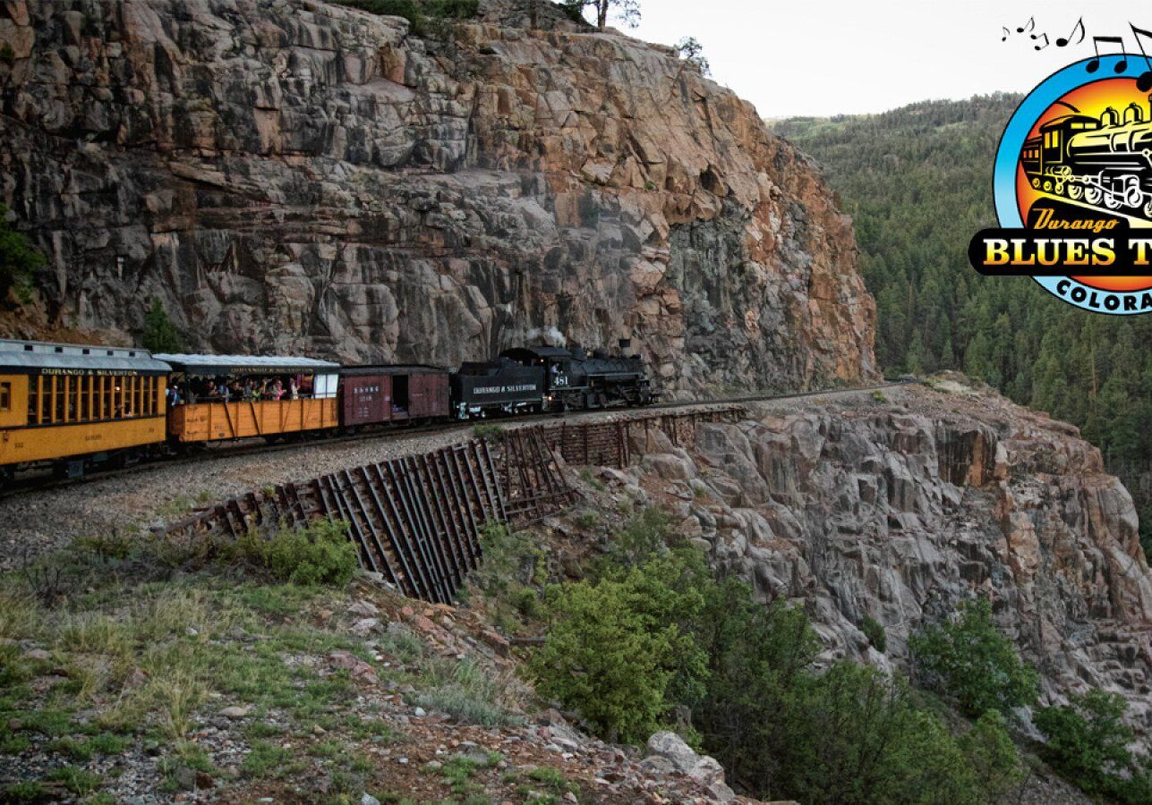 Train on mountain track with scenic backdrop.