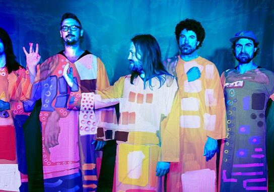 Five men in colorful, abstract outfits.