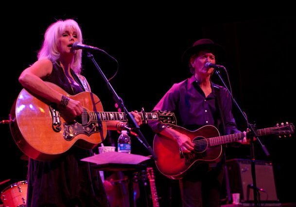 Two musicians performing on stage with guitars.