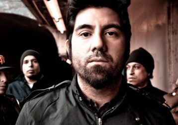 Five men standing in a dimly lit setting.