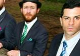 Three men in suits standing outdoors.