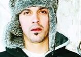 Man wearing a fur hat, neutral expression.