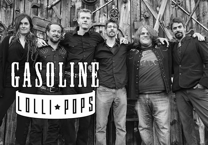 Band posing in front of wooden wall.