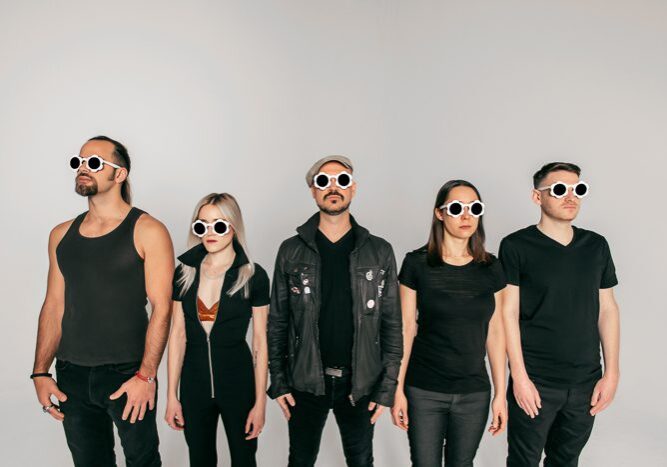 Five people wearing sunglasses, standing together.