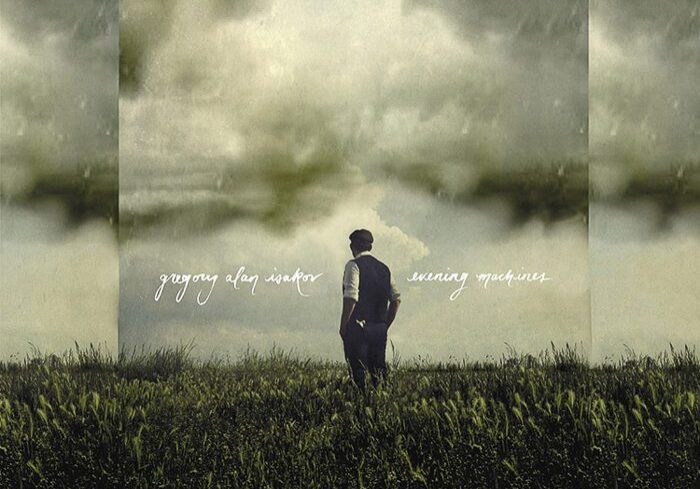 Man standing in a grassy field, cloudy sky.