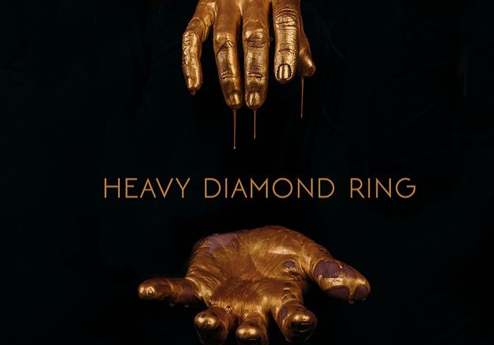 Gold hands sculpture with "Heavy Diamond Ring.