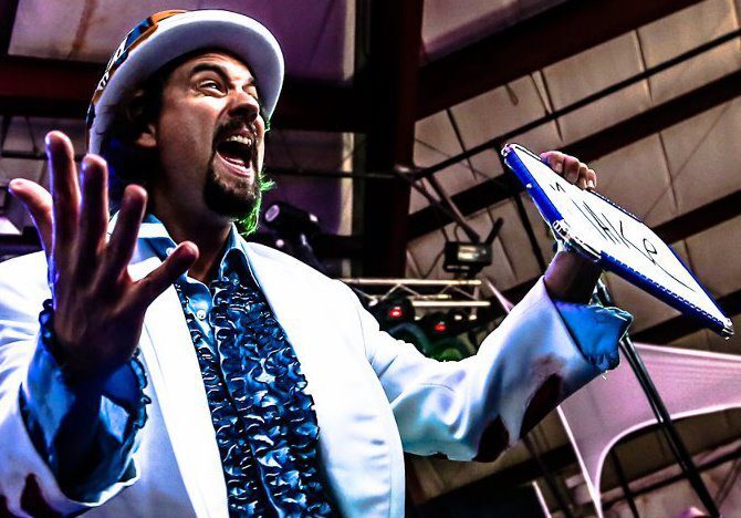 Man in costume performing with enthusiasm on stage.