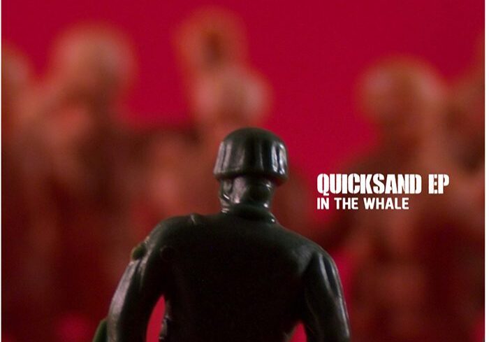 Toy soldier facing blurred figures, red background.
