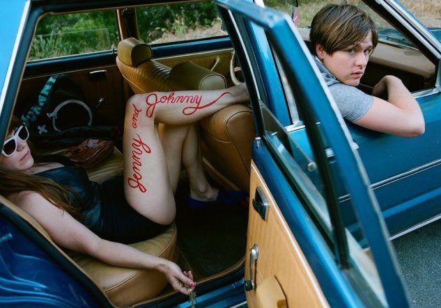 Two people in a vintage car.