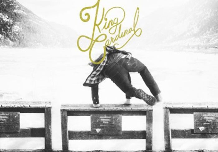 Person climbing over snowy wooden barrier.