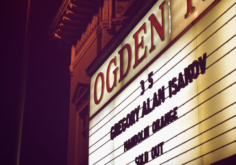 Theater marquee at night with event details.