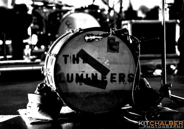 Drum with "The Lumineers" logo on stage.