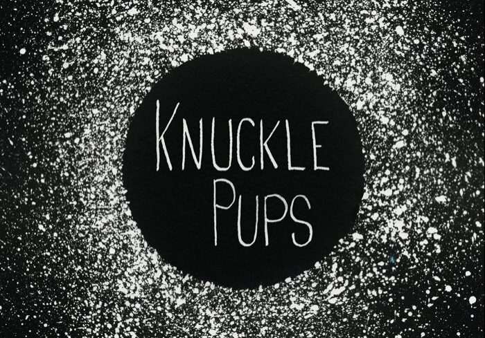 Knuckle Pups logo on splattered black background.