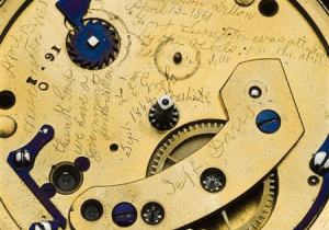 Antique watch mechanism with engraved text.