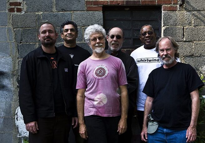 Group of six men standing together outside.