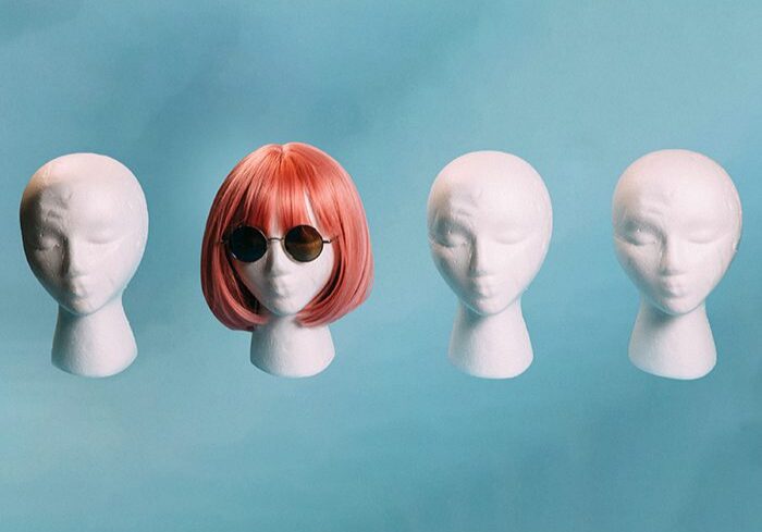 Mannequin heads with pink wig and sunglasses.