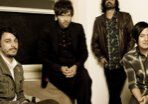 Four men posing in a room.