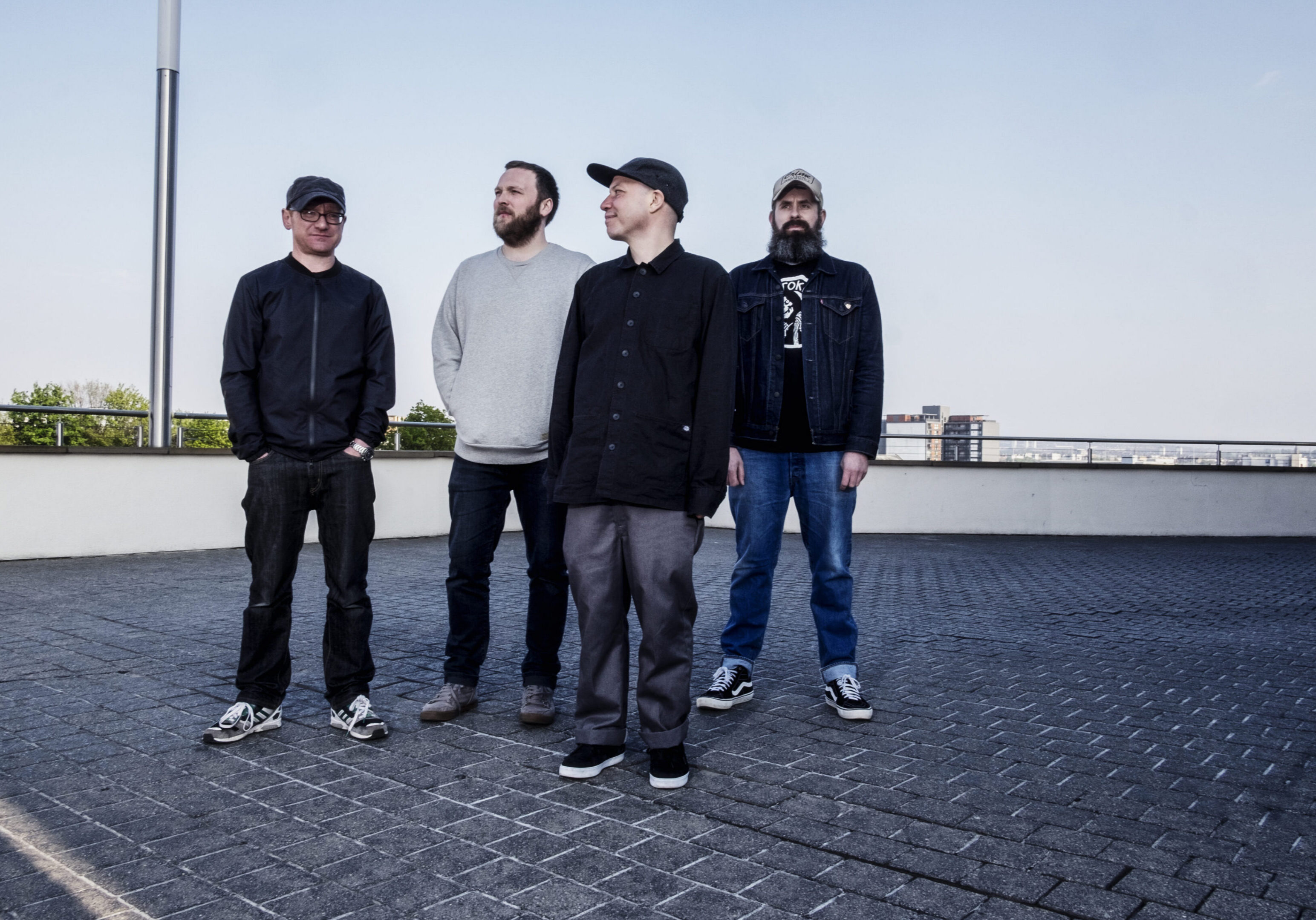 Four men standing on a rooftop.