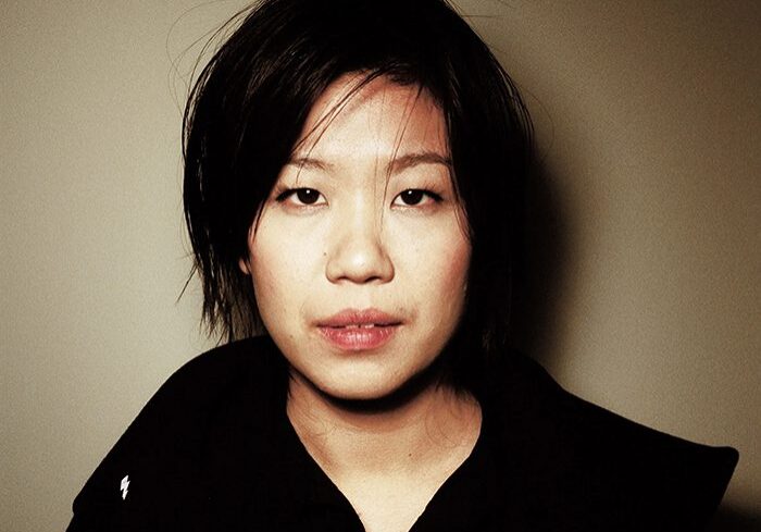 Person with short hair in dark clothing.