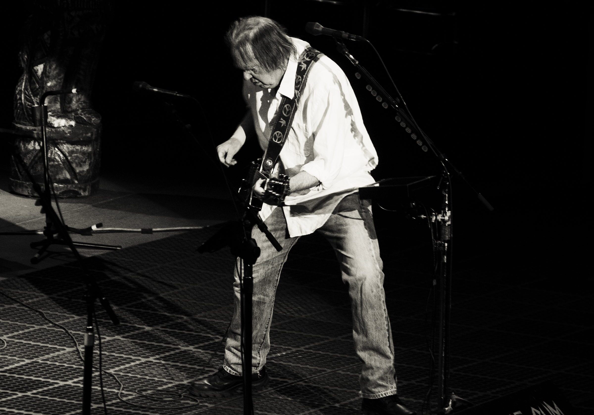 Guitarist performing energetically on stage, black and white.