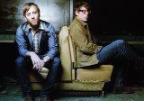 Two men sitting on an old couch.