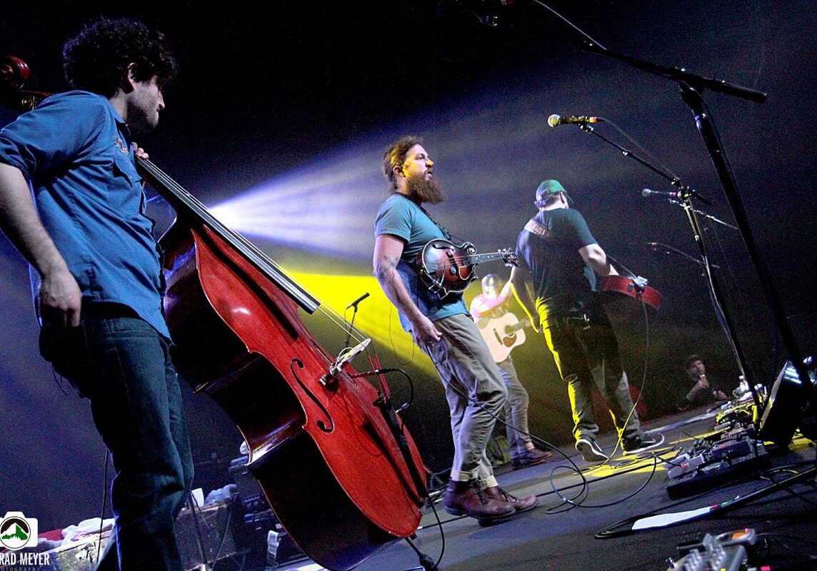 Band performing on stage with instruments.