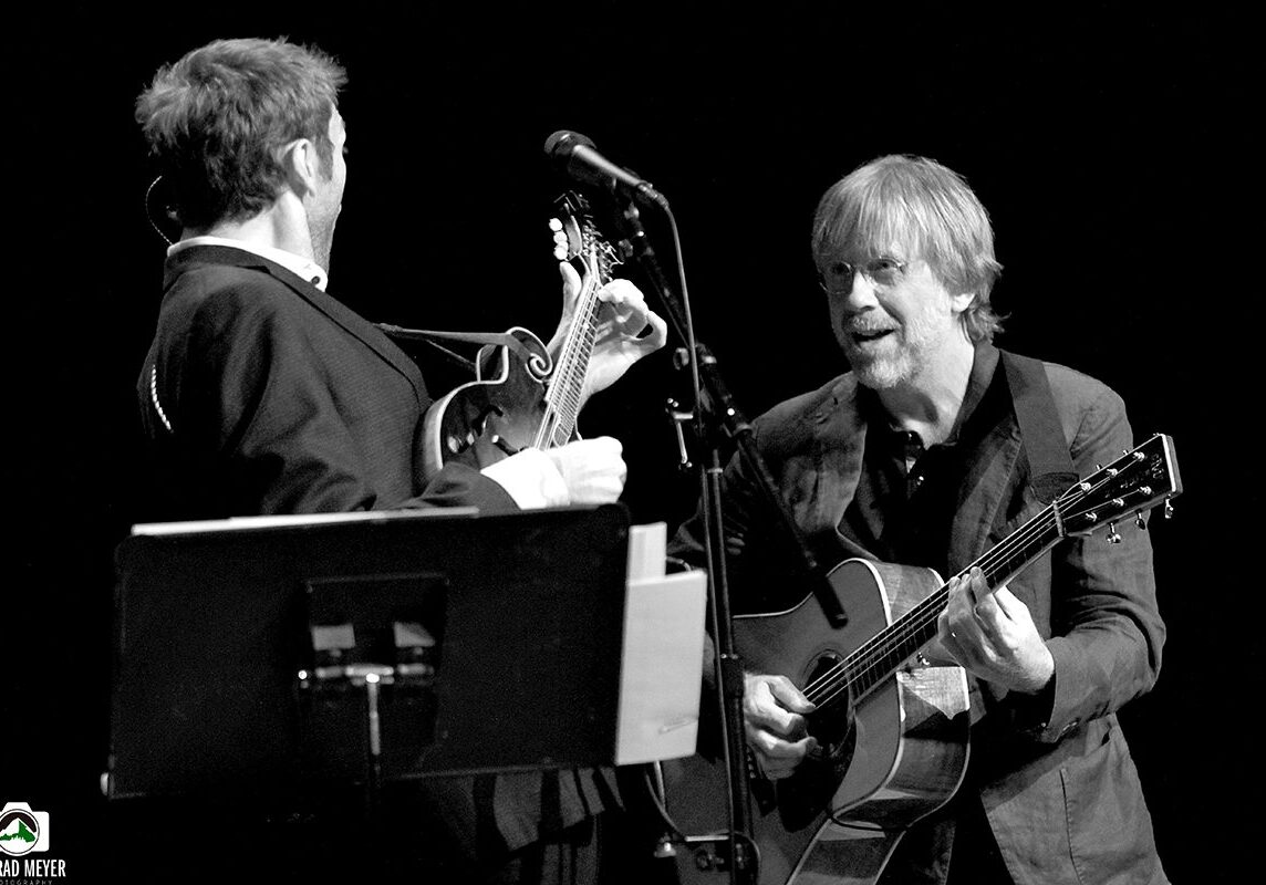 Two musicians performing on stage with guitars.