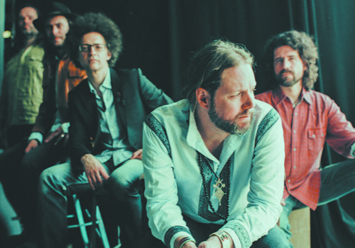 Band members sitting in a dimly lit room.
