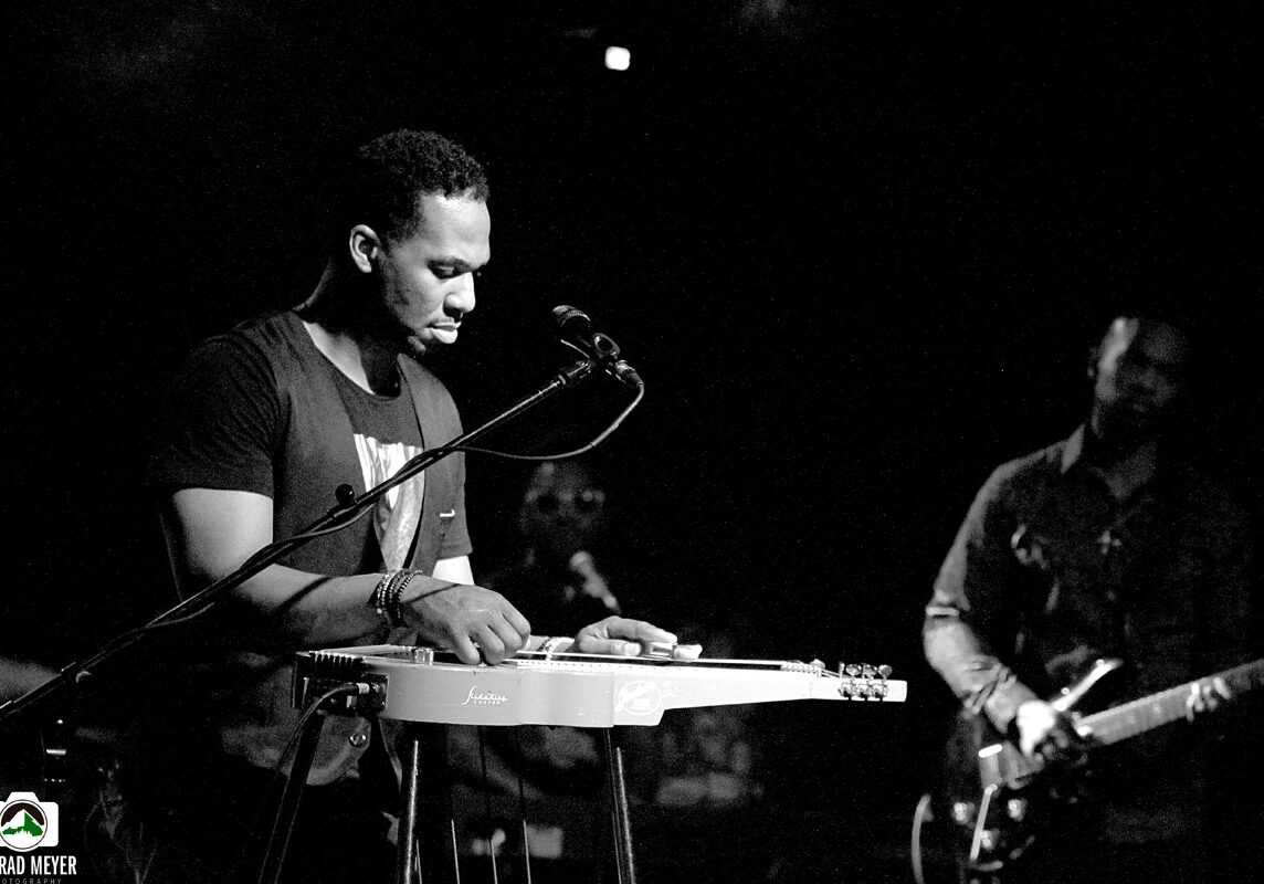 Musicians performing on stage in black and white.