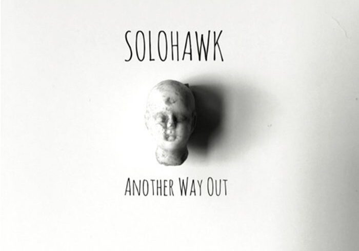 Album cover with a small head sculpture.