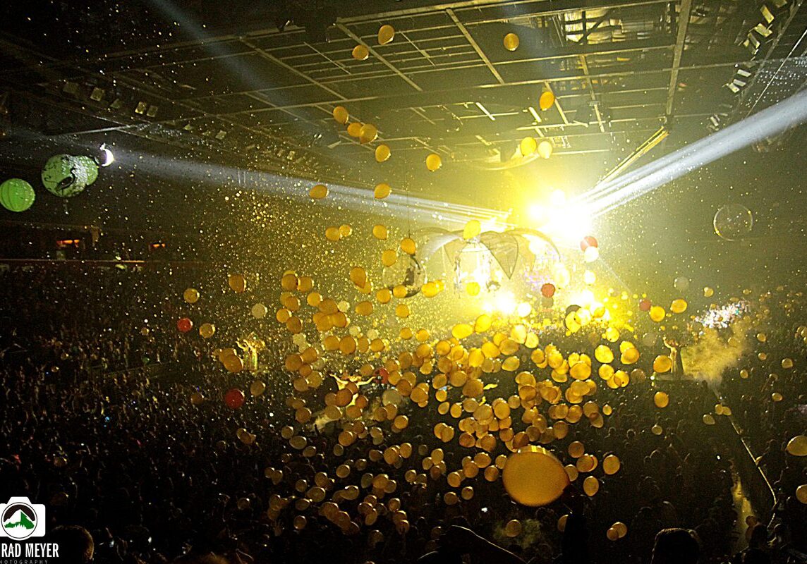Concert with balloons and bright stage lights.
