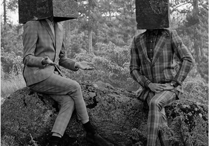 Two people with cube heads sitting outside.