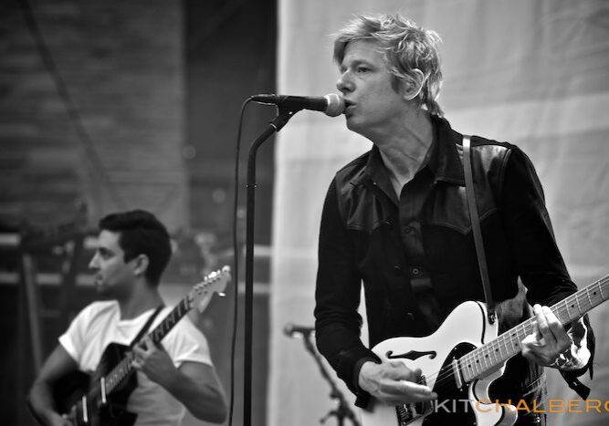 Musicians performing on stage with guitars.