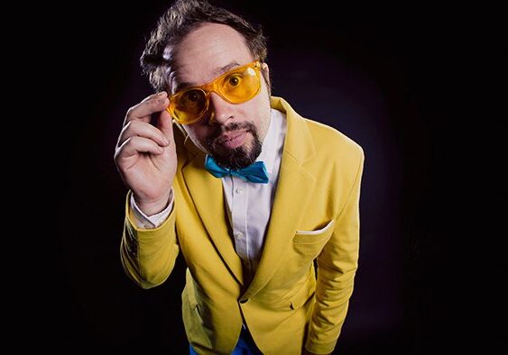 Man in yellow suit with orange glasses.