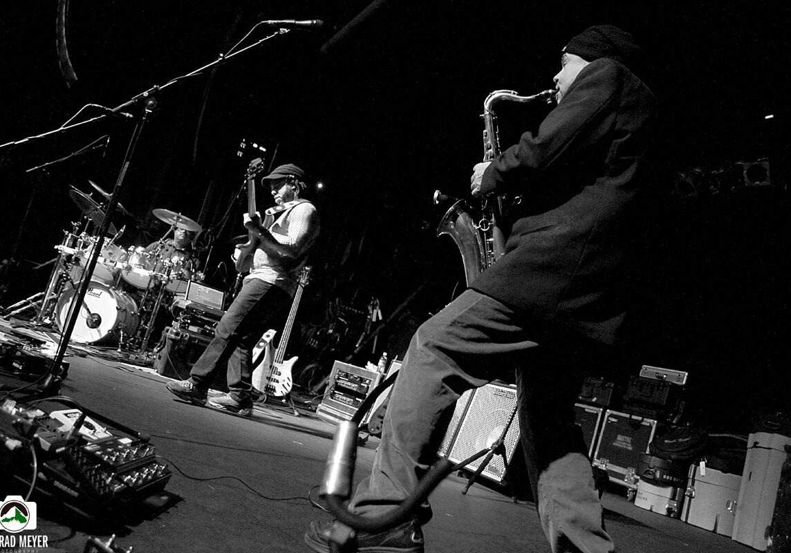 Band performing on stage with saxophonist.