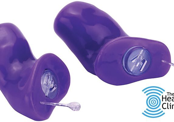 Purple hearing aids with logo of clinic.