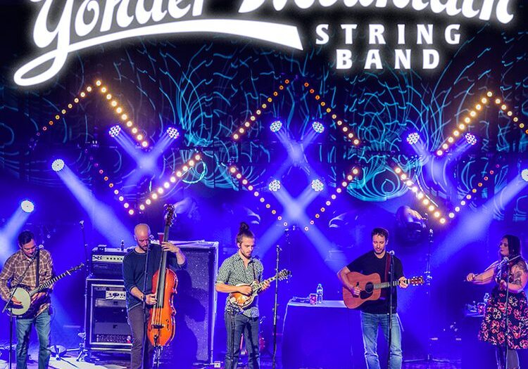 Band performing live on colorful stage.